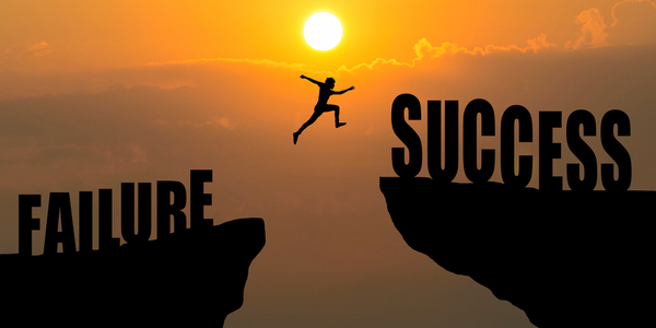 Man jumping over cliff with words "Failure" and "Sucess", to illustrate the idea of overcoming fear or "superar el miedo"